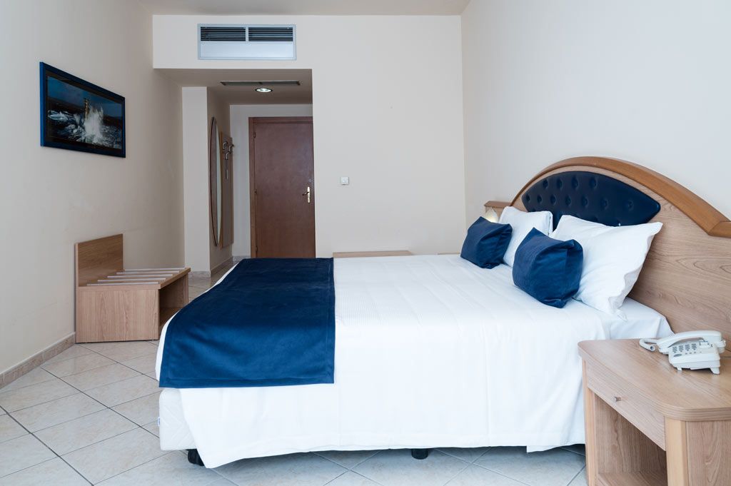 Camera della residenza con letto e testiera imbottita blu